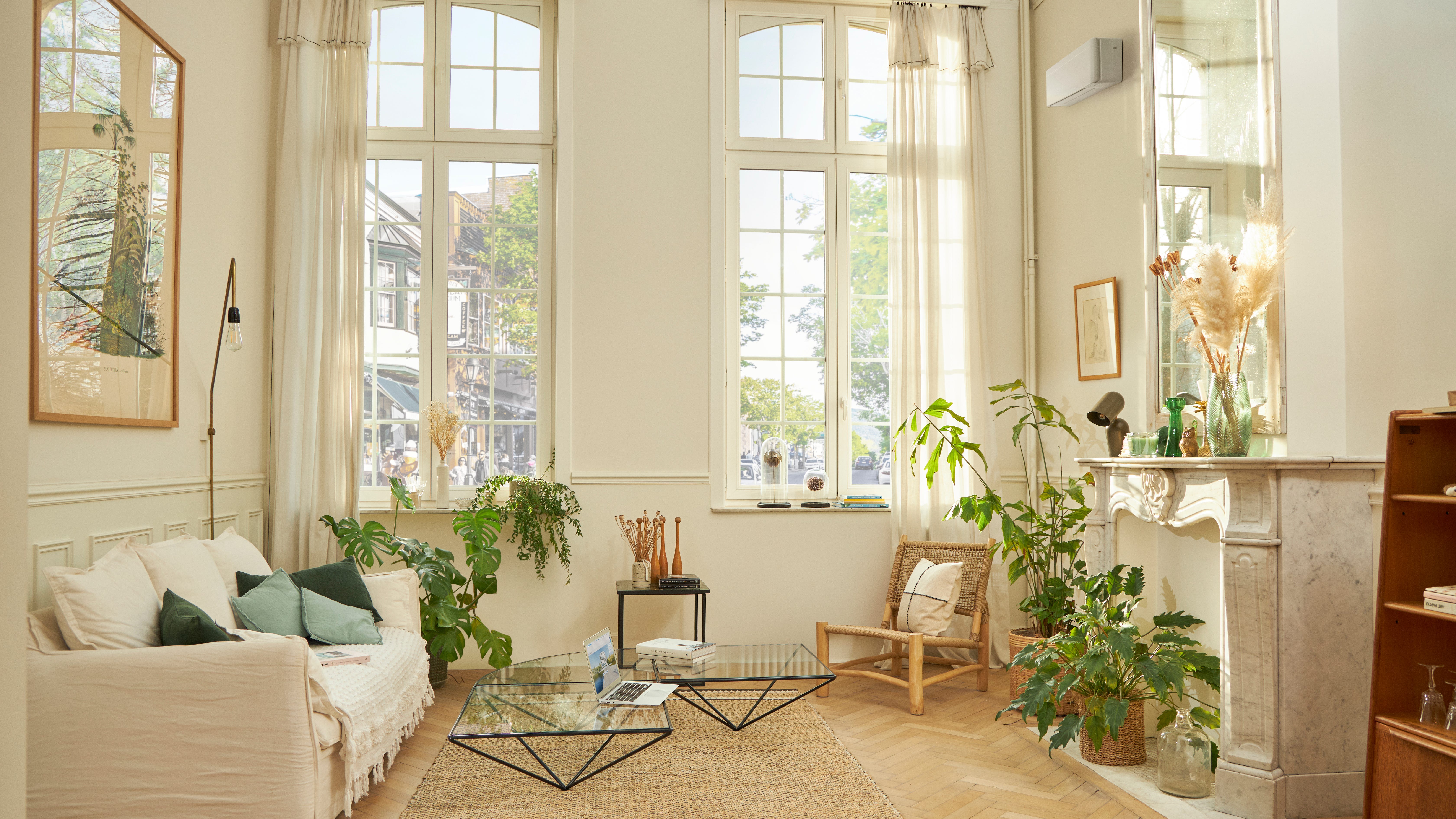 En smukt indrettet stue med et hvidt, vægmonteret klimasystem.